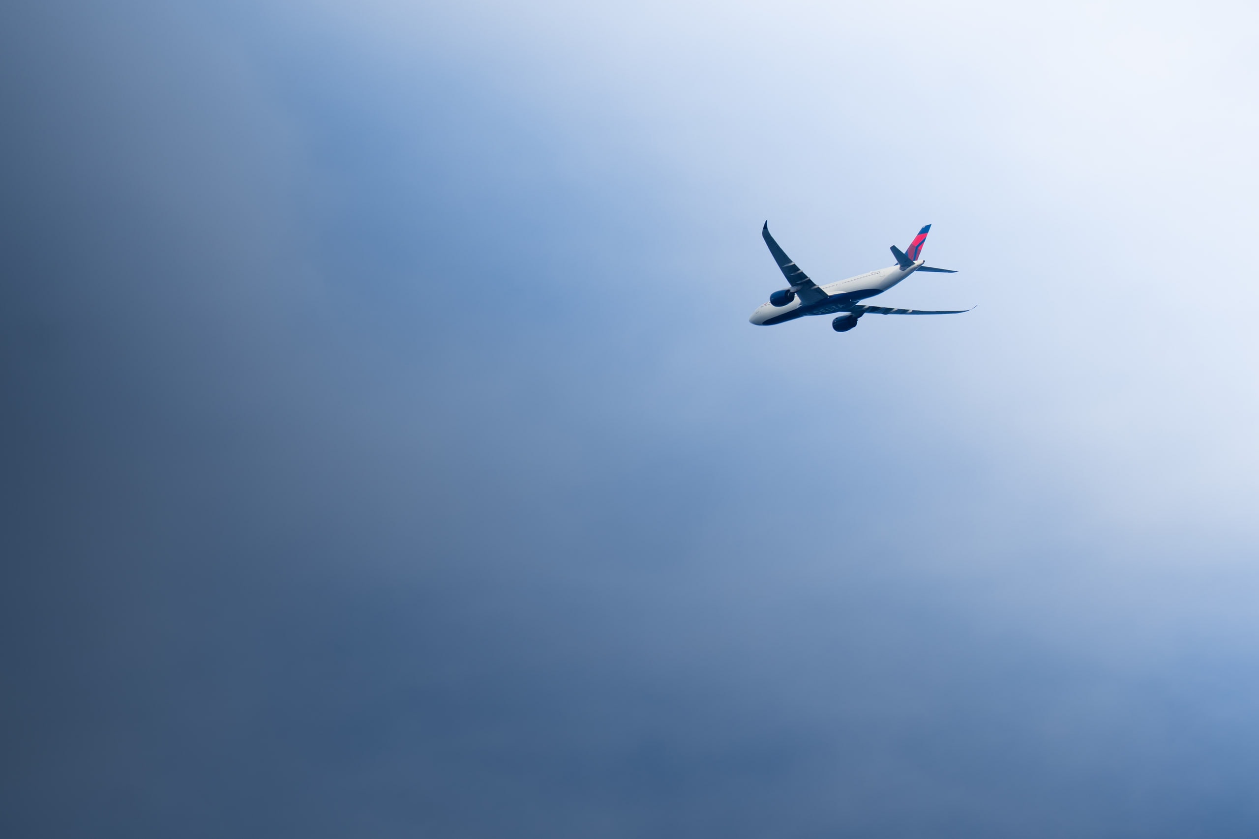 An airliner climbing through pale sky