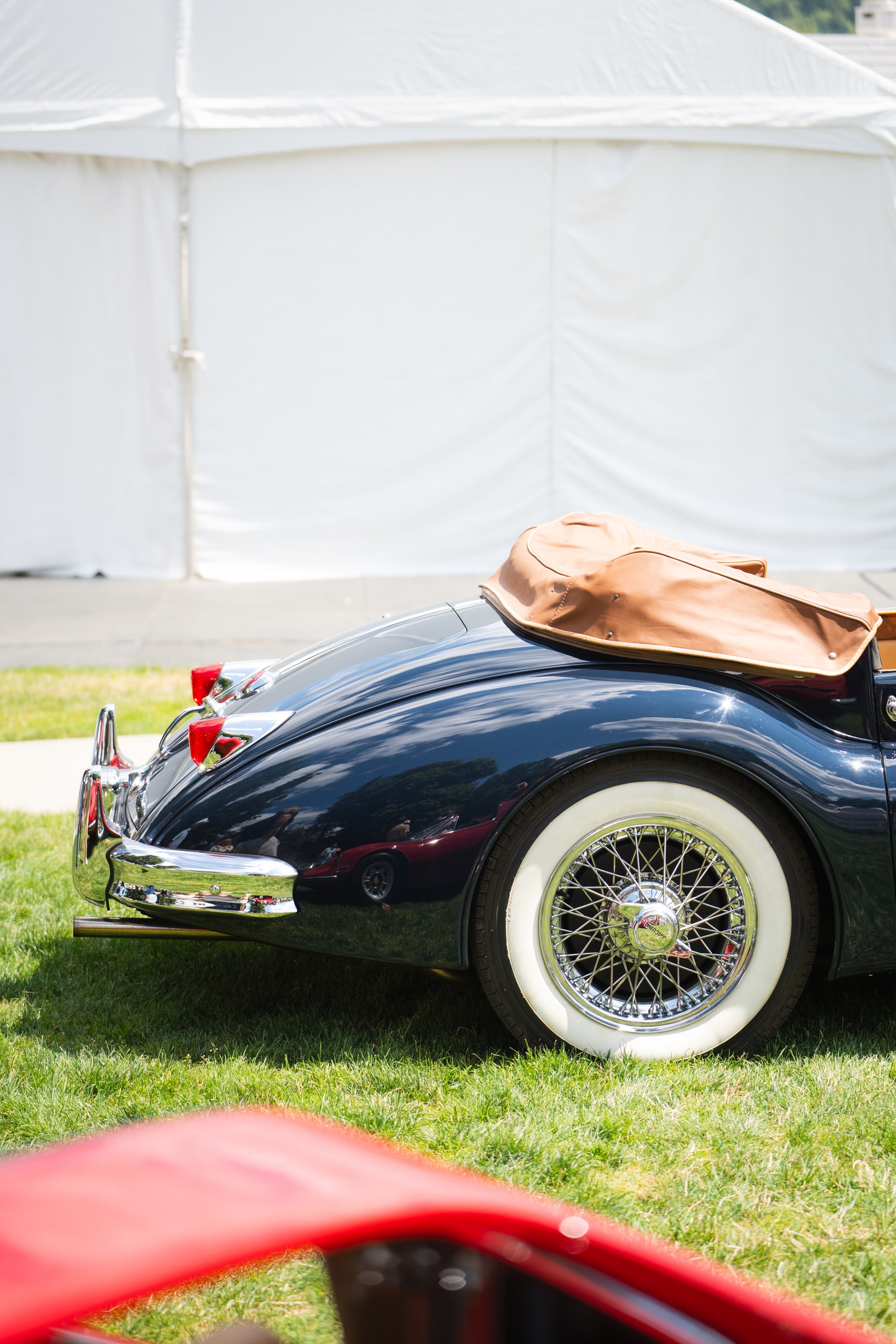 A classic convertible with wire wheels on a show field