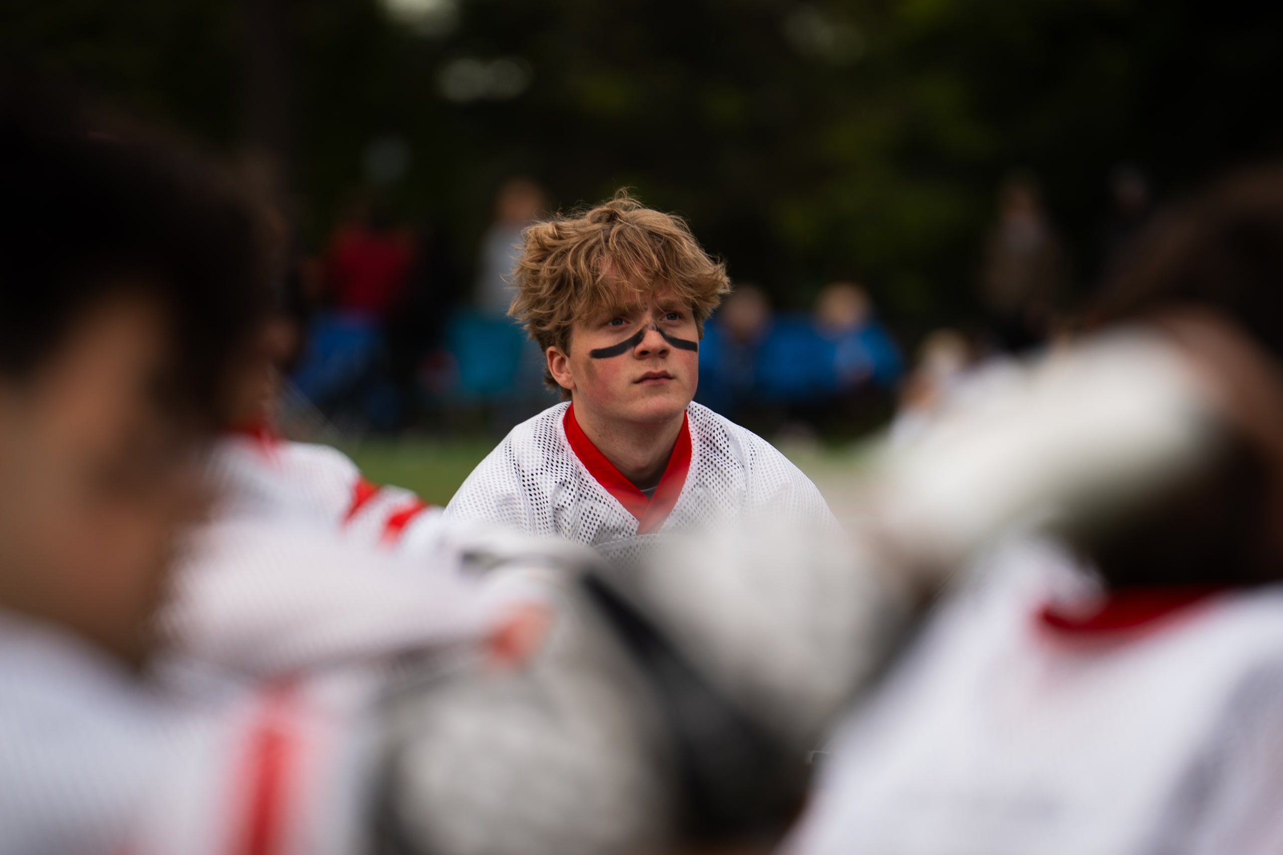 A lacrosse player looking out from among his teammates