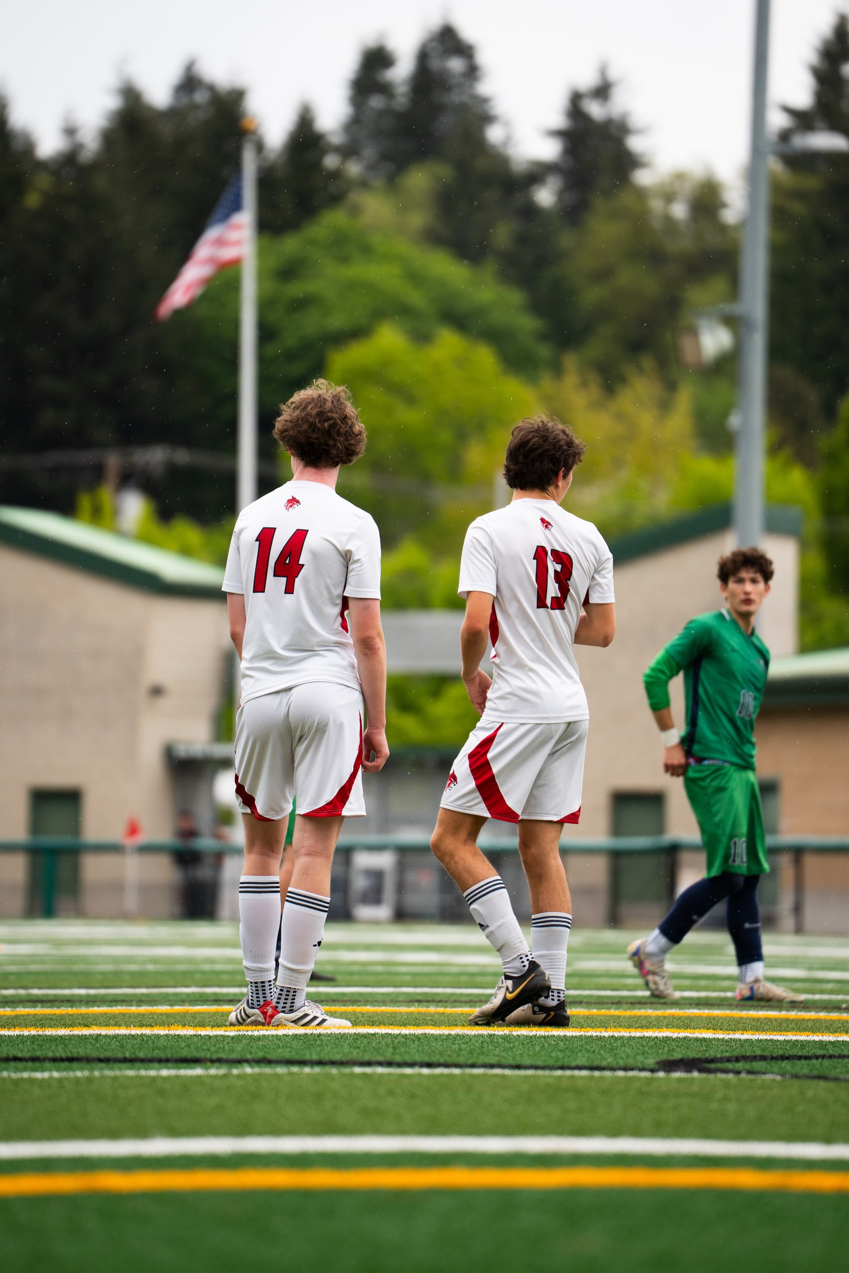Two outfield players and a keeper waiting during a stoppage